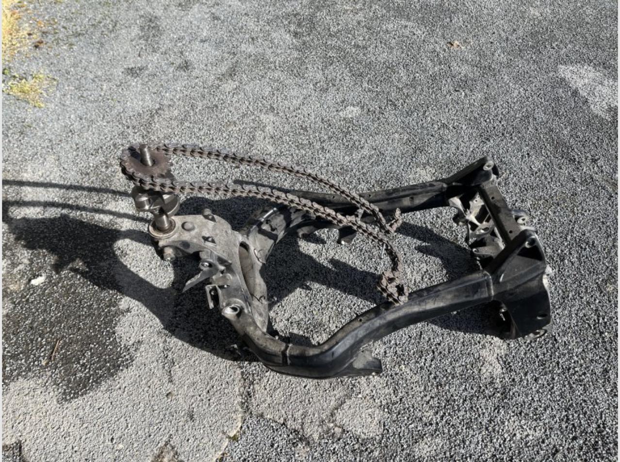 Cadre et bras oscillant de moto BMW K1200S récupérés, posés sur le sol