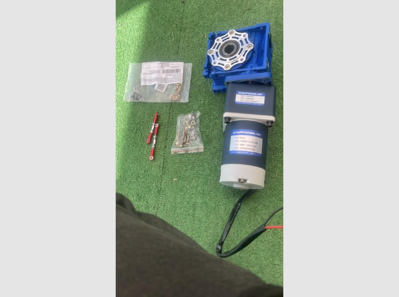 Moteur, réducteur et accessoires reçus, posés sur une pelouse